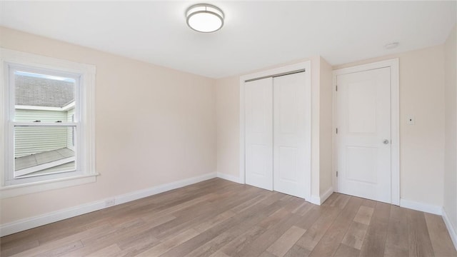 unfurnished bedroom with light hardwood / wood-style flooring and a closet