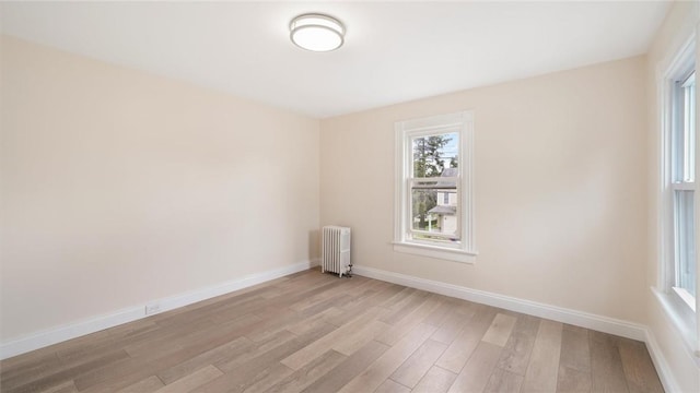 spare room with light hardwood / wood-style floors and radiator heating unit