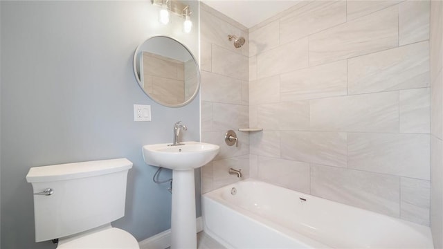 bathroom featuring tiled shower / bath combo and toilet