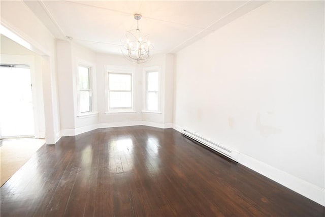 spare room with a chandelier, wood-type flooring, and a baseboard heating unit