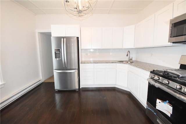 kitchen with appliances with stainless steel finishes, light stone counters, sink, white cabinets, and dark hardwood / wood-style floors