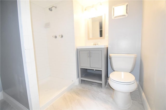 bathroom with vanity, toilet, and a tile shower