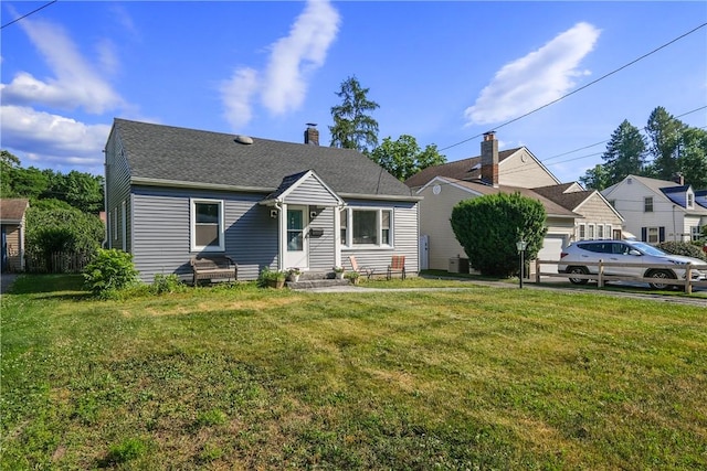 view of front of home with central AC unit and a front lawn