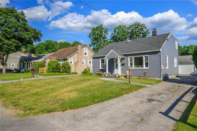 view of front of home featuring an outbuilding, a front yard, and a garage