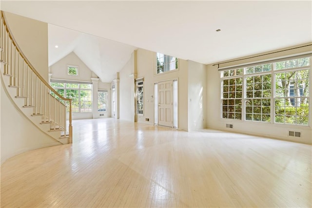 foyer entrance featuring high vaulted ceiling and light hardwood / wood-style flooring