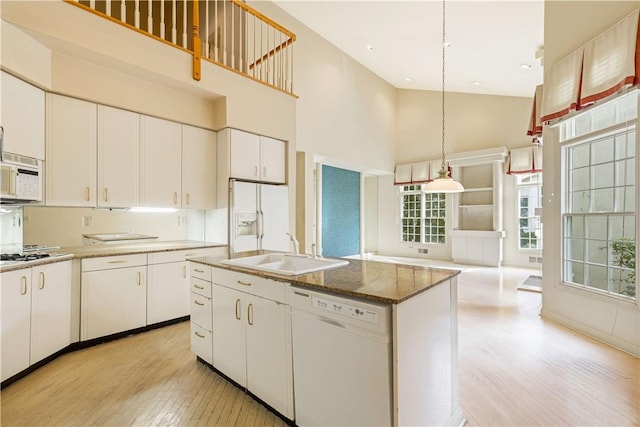 kitchen featuring white cabinetry, sink, high vaulted ceiling, light hardwood / wood-style floors, and white appliances