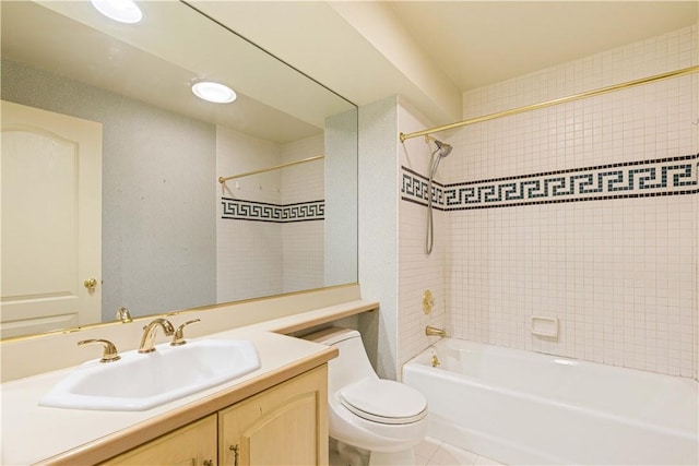 full bathroom with tile patterned flooring, vanity, tiled shower / bath combo, and toilet