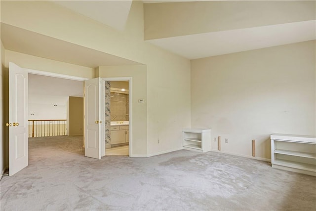 unfurnished bedroom with light colored carpet and ensuite bath