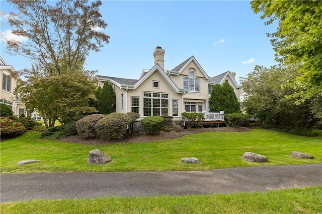 view of front facade featuring a front lawn and a wooden deck