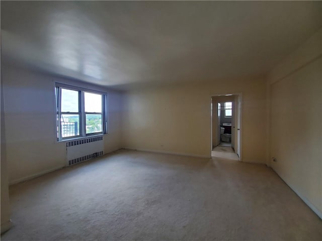 carpeted empty room featuring radiator