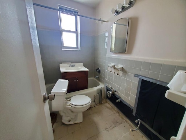 full bathroom featuring vanity, toilet, tile walls, and tub / shower combination