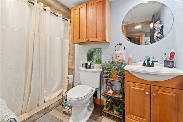 bathroom with a shower with curtain, vanity, hardwood / wood-style flooring, and toilet