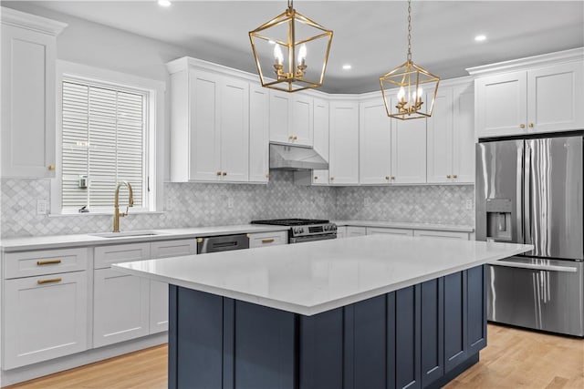 kitchen with white cabinetry, sink, hanging light fixtures, and appliances with stainless steel finishes