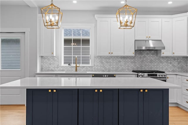 kitchen featuring stainless steel range, pendant lighting, a center island, and exhaust hood