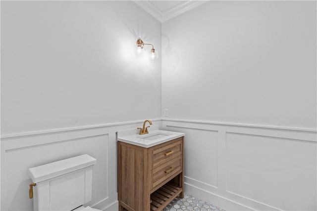 bathroom featuring vanity, toilet, and ornamental molding