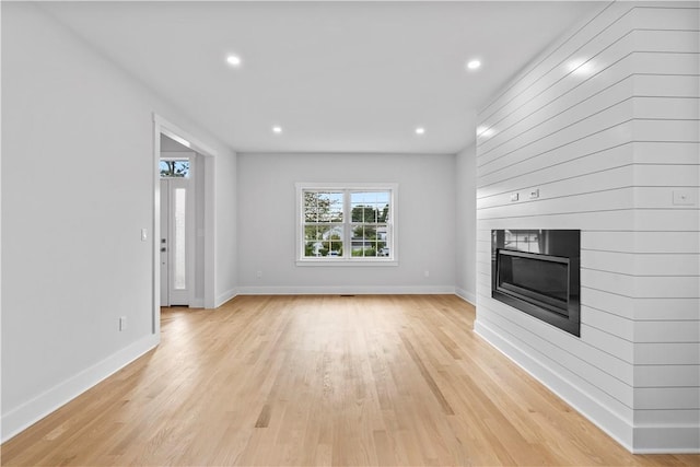 unfurnished living room with light wood-type flooring and a fireplace