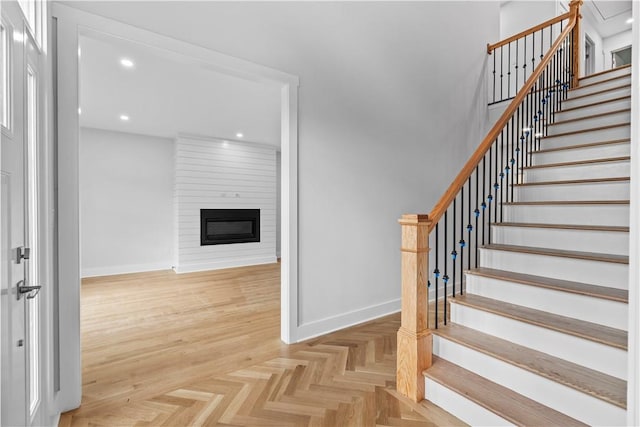 stairs with a fireplace and parquet floors