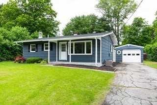 view of front facade featuring an outbuilding, a front yard, and a garage