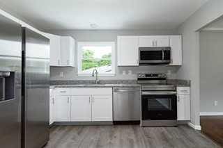 kitchen featuring stainless steel appliances, white cabinetry, light hardwood / wood-style floors, and sink