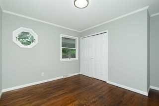 unfurnished bedroom with crown molding and dark wood-type flooring