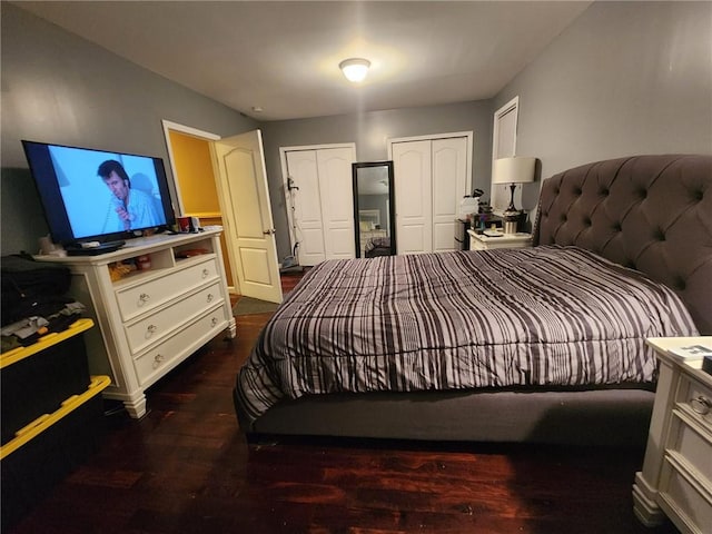 bedroom featuring multiple closets and dark wood-type flooring