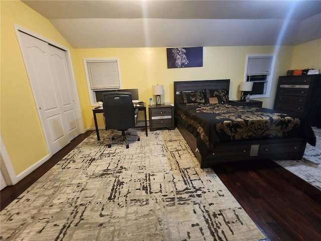 bedroom featuring hardwood / wood-style flooring, vaulted ceiling, and a closet