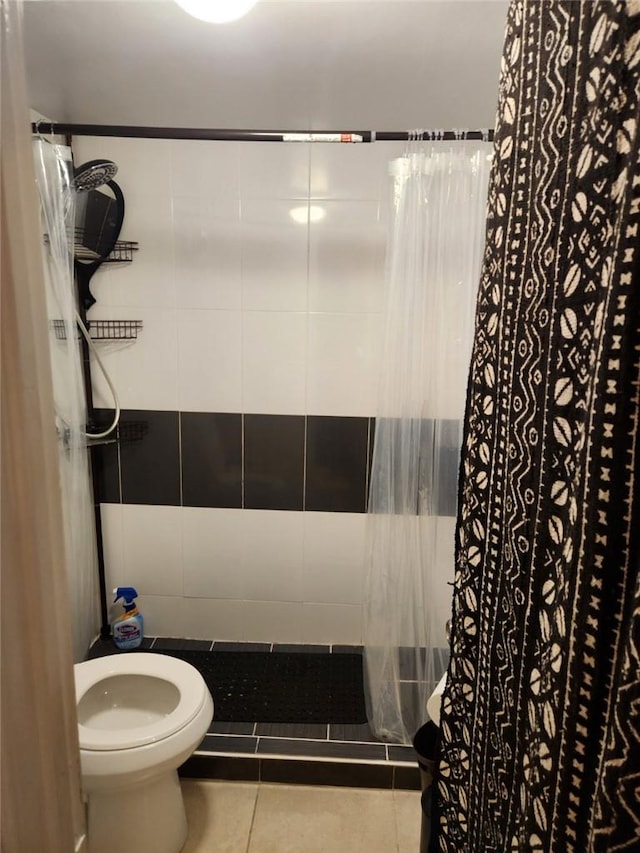 bathroom with tile patterned floors, walk in shower, tile walls, and toilet