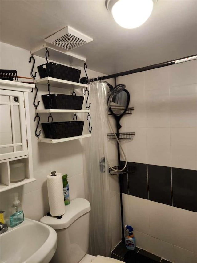 bathroom with toilet, sink, and walk in shower