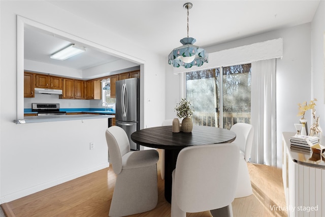 dining room with sink, plenty of natural light, and light hardwood / wood-style flooring