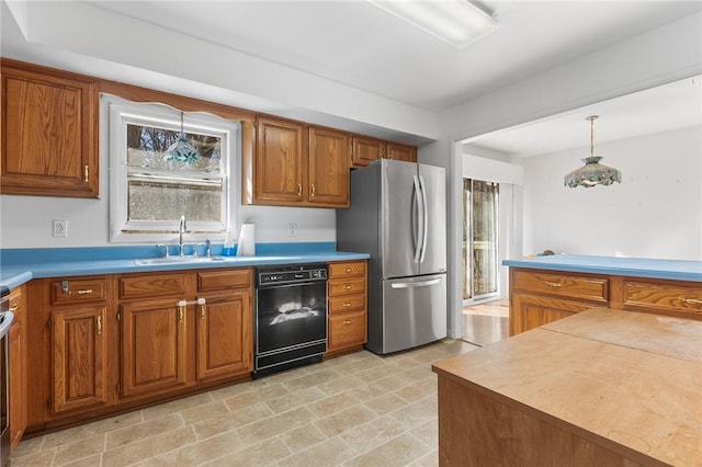 kitchen with dishwasher, stainless steel fridge, hanging light fixtures, and sink