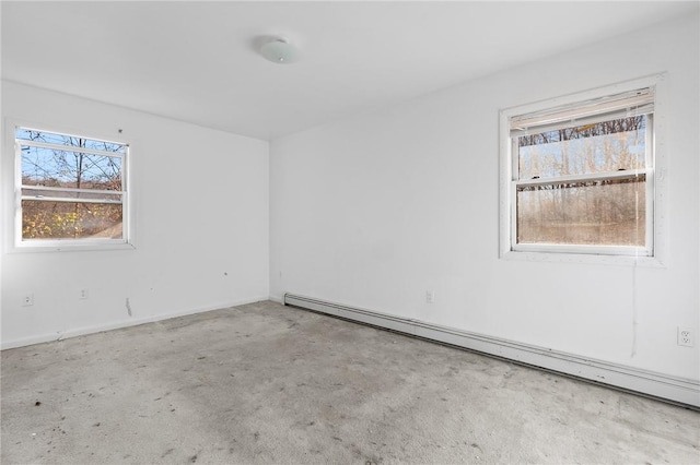 spare room featuring light carpet and a baseboard heating unit