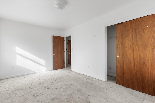 unfurnished bedroom with light colored carpet and a closet