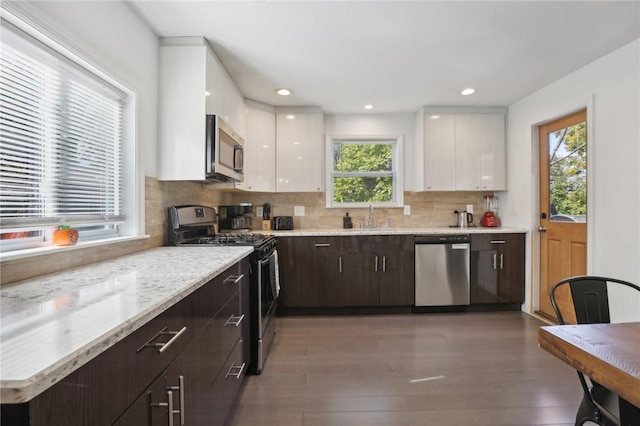 kitchen with dark hardwood / wood-style floors, dark brown cabinetry, white cabinetry, and appliances with stainless steel finishes