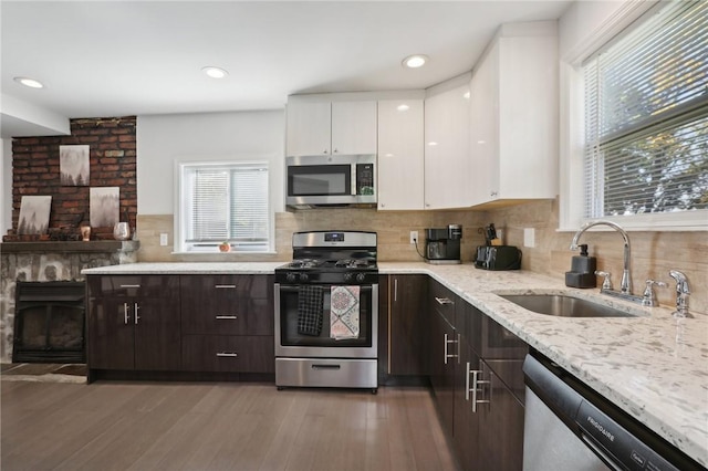 kitchen featuring dark brown cabinets, a healthy amount of sunlight, white cabinetry, and stainless steel appliances