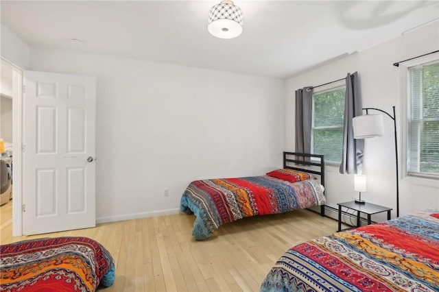 bedroom featuring wood-type flooring and washer / dryer