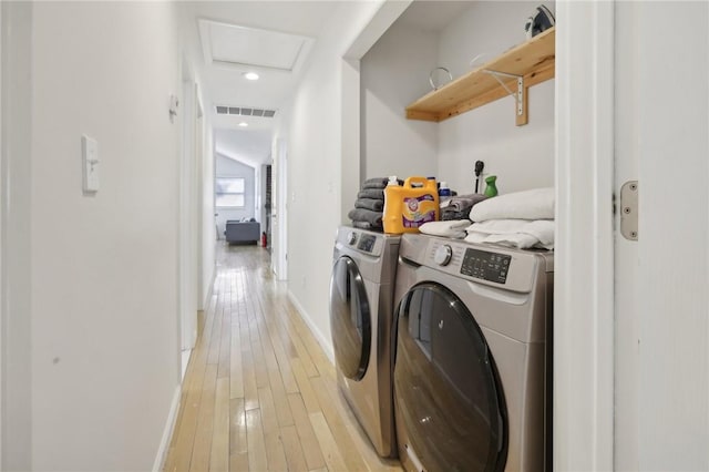 clothes washing area featuring light hardwood / wood-style floors and washing machine and clothes dryer