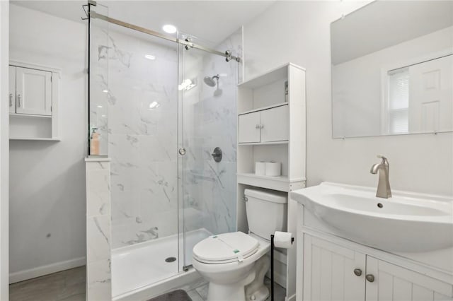 bathroom with vanity, toilet, and a shower with door