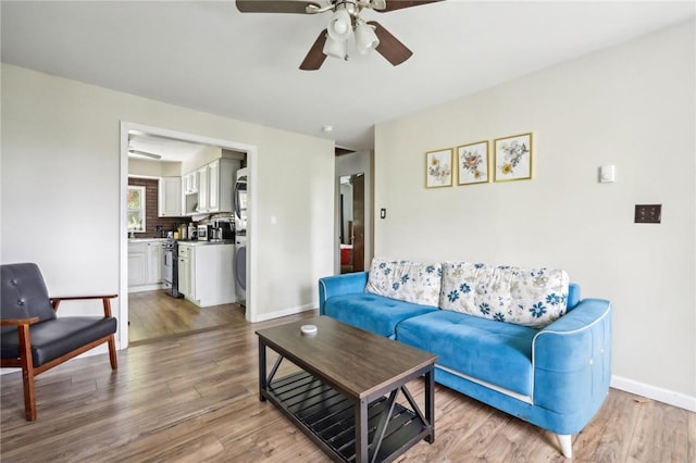 living room with ceiling fan and light wood-type flooring