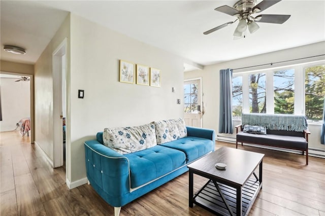 living room featuring ceiling fan, a baseboard heating unit, and hardwood / wood-style flooring