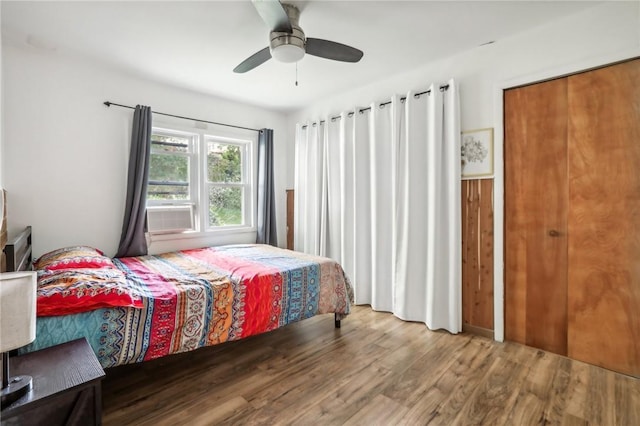 bedroom with wood-type flooring, ceiling fan, and cooling unit