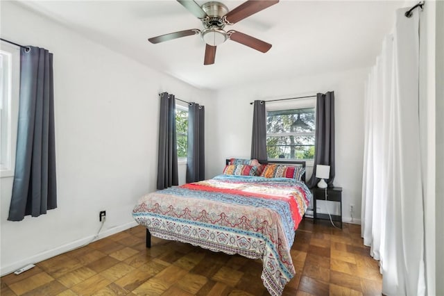 bedroom with dark parquet flooring and ceiling fan