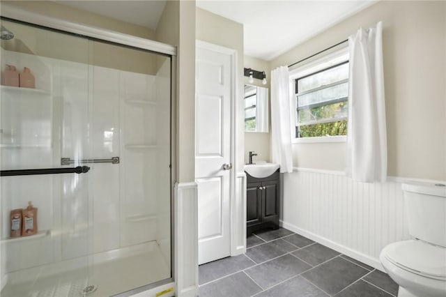 bathroom with tile patterned flooring, vanity, toilet, and a shower with shower door