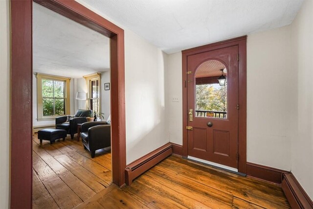 entryway featuring a wealth of natural light, a baseboard radiator, and dark hardwood / wood-style floors