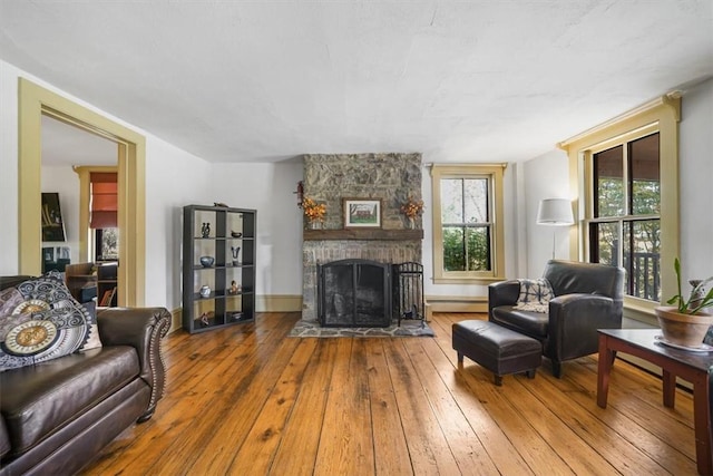 living room featuring a fireplace, a baseboard radiator, and hardwood / wood-style flooring