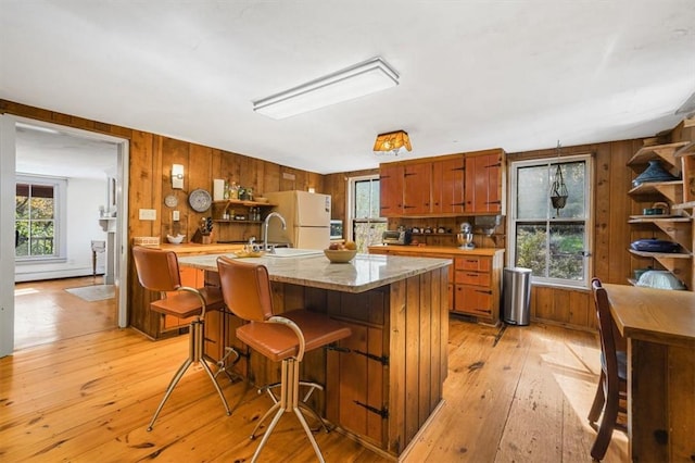 kitchen featuring white refrigerator, light hardwood / wood-style flooring, and a healthy amount of sunlight