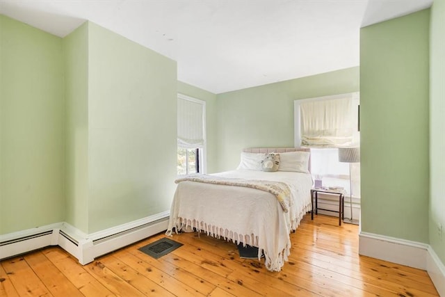 bedroom featuring light hardwood / wood-style flooring and baseboard heating