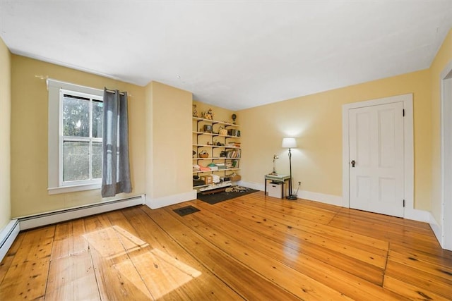 interior space featuring baseboard heating and wood-type flooring