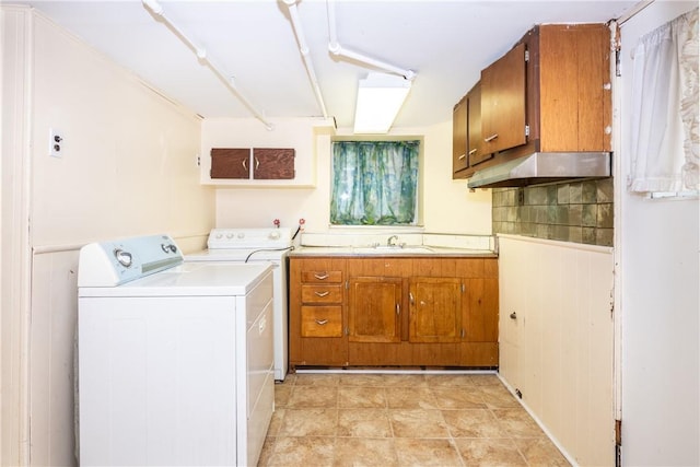 laundry area with cabinets, washer and dryer, and sink