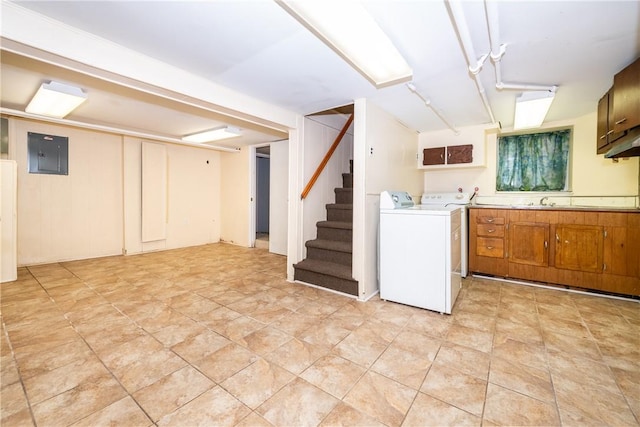 washroom featuring electric panel, washer and clothes dryer, cabinets, and sink