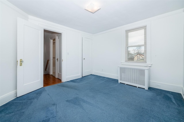 carpeted spare room with radiator heating unit and ornamental molding